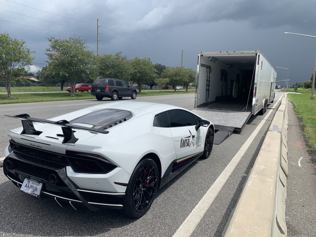 Lamborghini being loaded onto an enclosed carrier for auto show transport