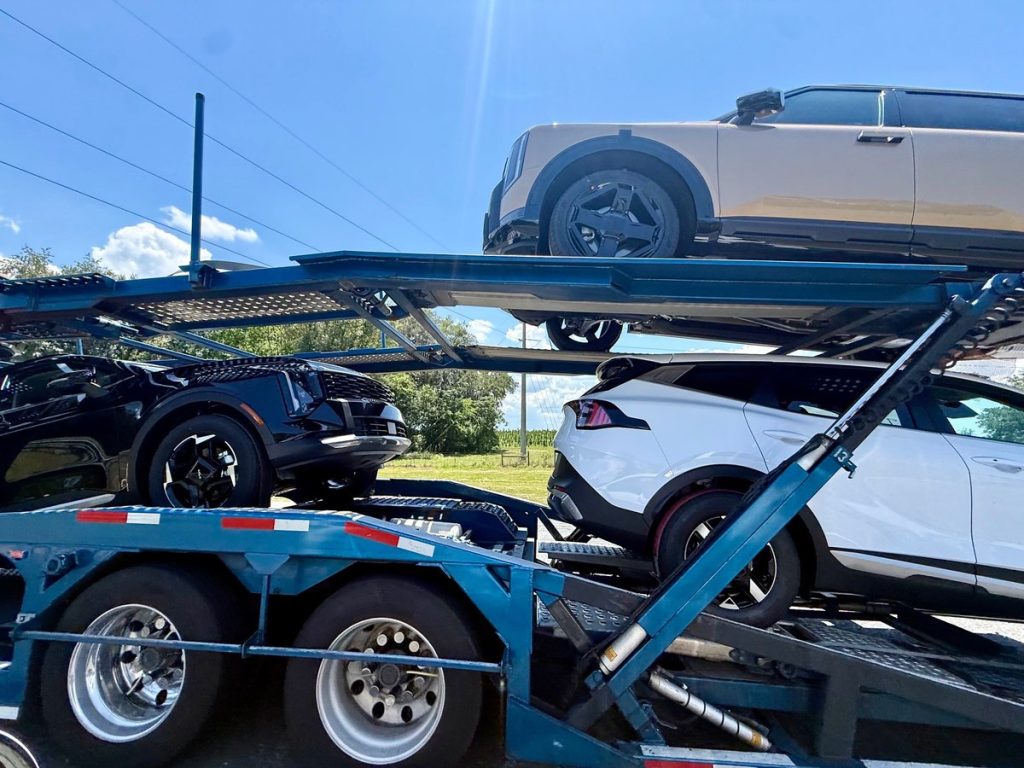 Multiple vehicles loaded on an open auto transport carrier