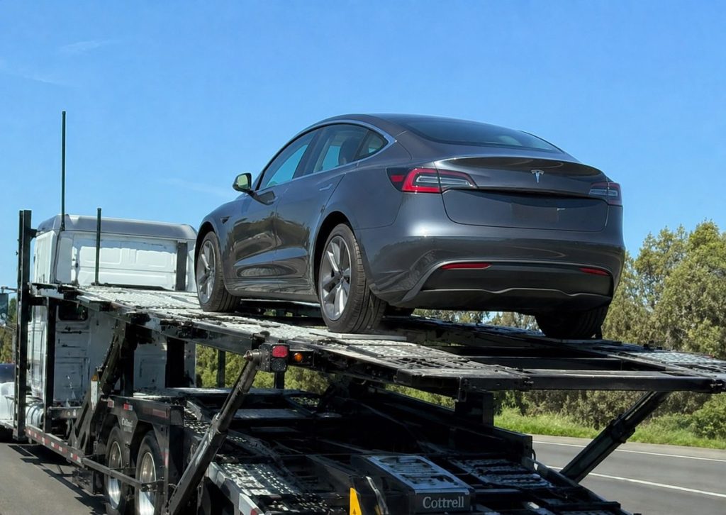 Tesla Model 3 on an open auto transport carrier