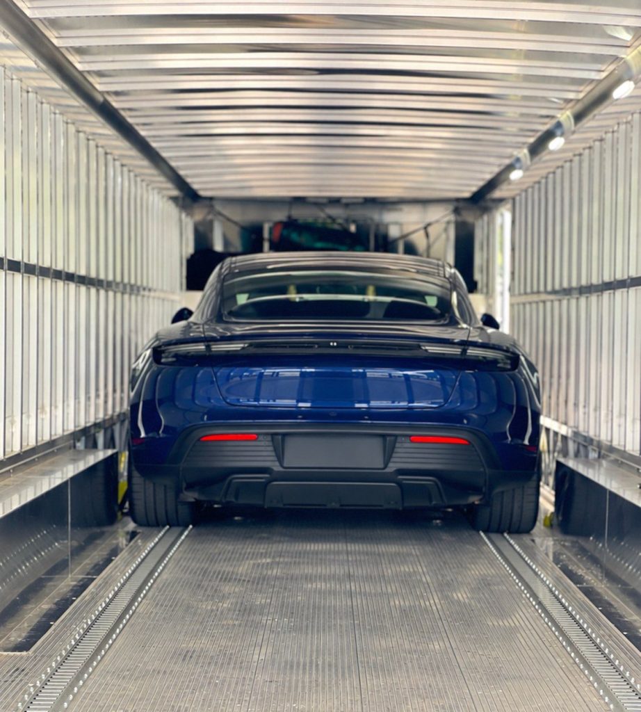 Porsche Taycan inside an enclosed auto transport trailer